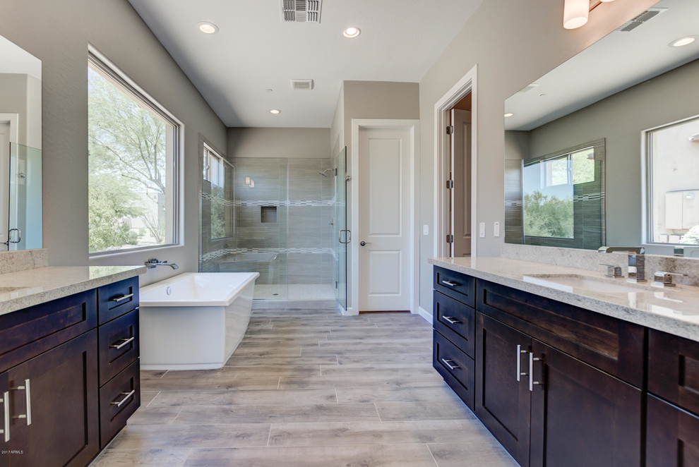 Inspiration for a large southwestern master beige tile and porcelain tile light wood floor and beige floor bathroom remodel in Phoenix with shaker cabinets, dark wood cabinets, beige walls, an undermount sink, granite countertops and a hinged shower door