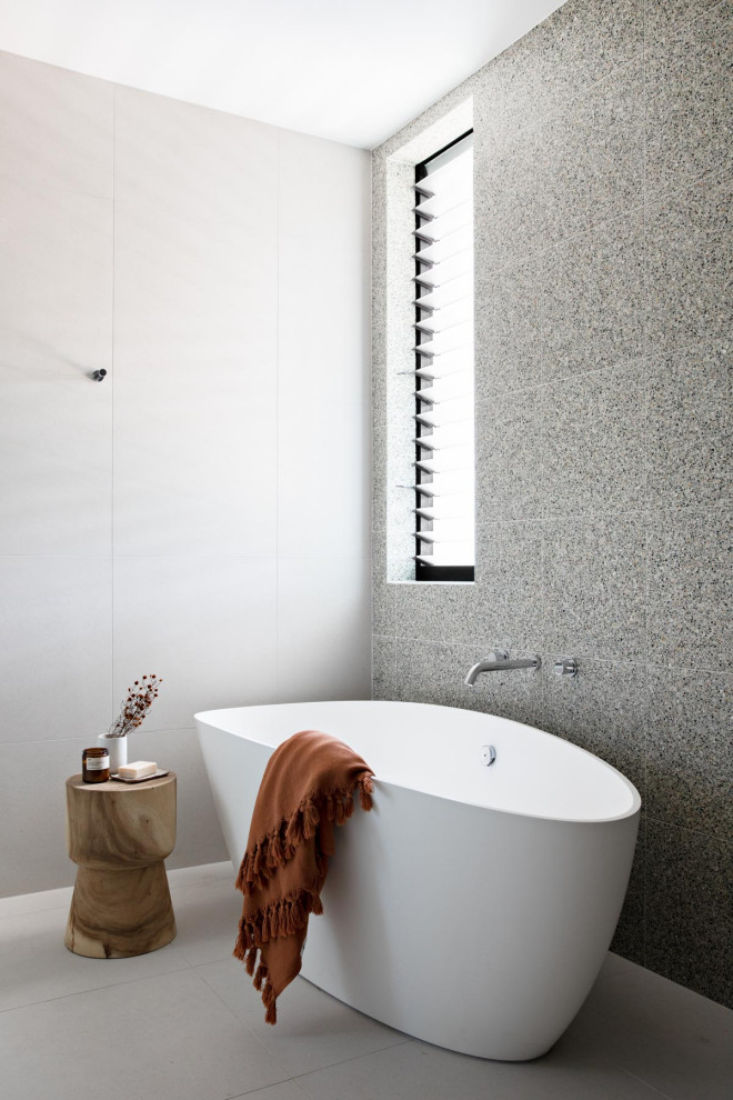 Идея дизайна: ванная комната в стиле модернизм с отдельно стоящей ванной и серой плиткой