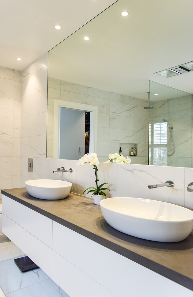 Design ideas for a large contemporary wet room bathroom in Melbourne with flat-panel cabinets, white cabinets, a freestanding bath, white tiles, white walls, a vessel sink, engineered stone worktops, white floors and an open shower.