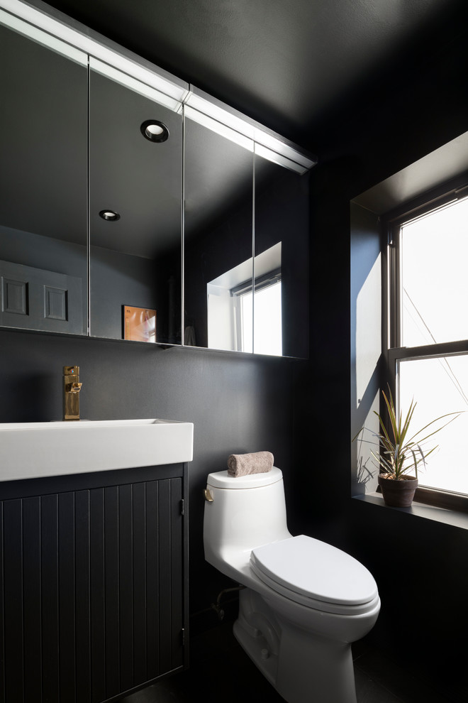 Danish black floor bathroom photo in New York with black cabinets, black walls and a console sink