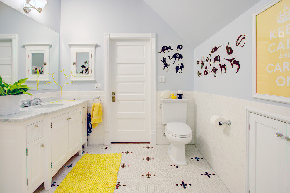 Bild på ett mellanstort vintage grå grått badrum för barn, med tunnelbanekakel, luckor med infälld panel, vita skåp, en toalettstol med separat cisternkåpa, vit kakel, grå väggar, ett undermonterad handfat, marmorbänkskiva, mosaikgolv och vitt golv