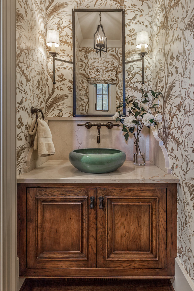 Small tuscan dark wood floor and brown floor powder room photo in Other with medium tone wood cabinets, recessed-panel cabinets, a one-piece toilet, multicolored walls, a vessel sink and quartzite countertops