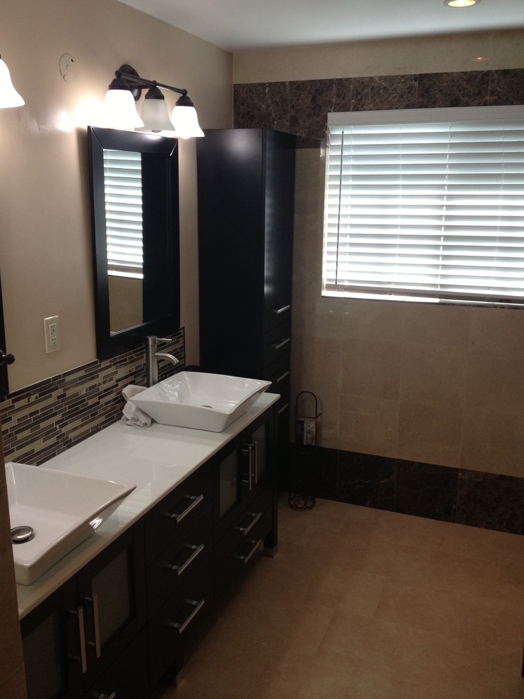 Example of a mid-sized transitional 3/4 beige tile, brown tile and glass tile ceramic tile and beige floor bathroom design in Los Angeles with furniture-like cabinets, dark wood cabinets, beige walls, a vessel sink, solid surface countertops and a hinged shower door