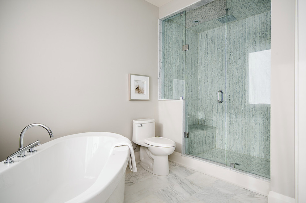 Photo of a medium sized modern shower room bathroom in Toronto with raised-panel cabinets, white cabinets, a freestanding bath, a walk-in shower, a one-piece toilet, grey tiles, white tiles, stone tiles, white walls, marble flooring, a built-in sink and marble worktops.