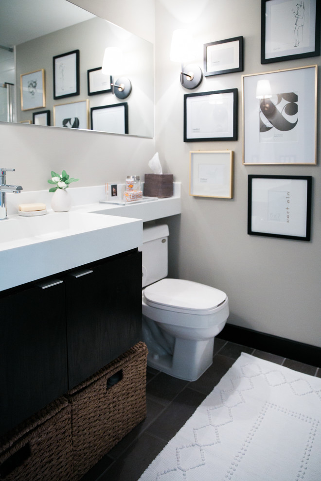 Esempio di una piccola stanza da bagno eclettica con ante lisce, ante in legno bruno, WC monopezzo, pareti grigie, pavimento con piastrelle in ceramica, lavabo integrato e top in superficie solida
