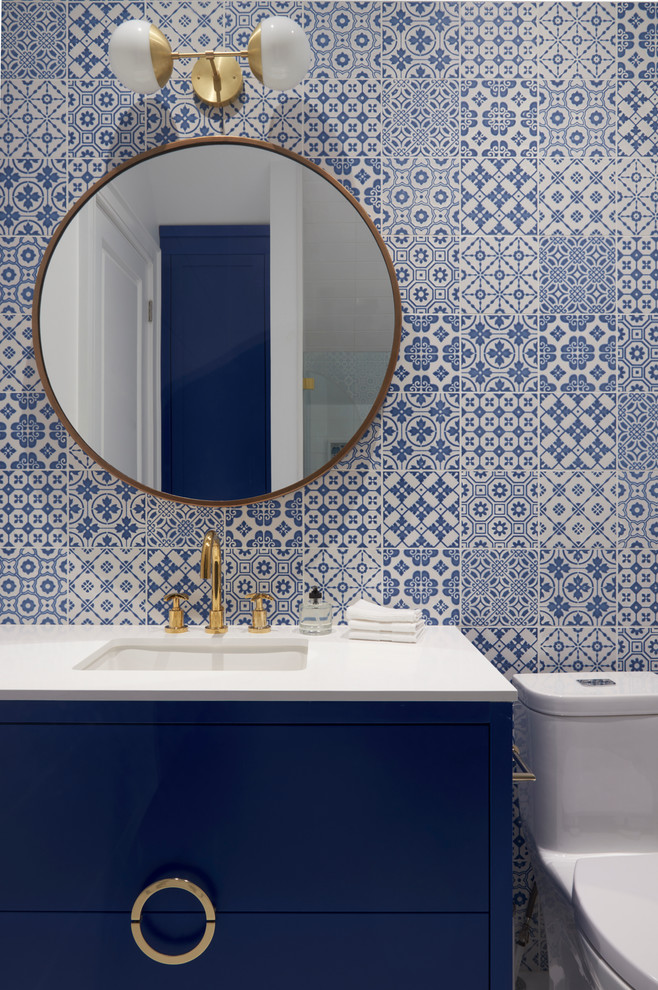 トロントにあるコンテンポラリースタイルのおしゃれな浴室 (青いキャビネット、一体型トイレ	、マルチカラーの壁、アンダーカウンター洗面器、フラットパネル扉のキャビネット) の写真