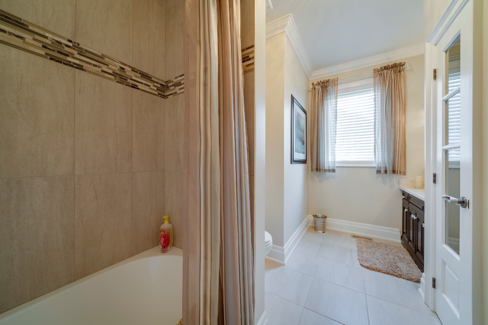 Idée de décoration pour une salle de bain tradition en bois foncé avec un lavabo intégré, un placard en trompe-l'oeil, un plan de toilette en marbre, un combiné douche/baignoire, un carrelage blanc et des carreaux de porcelaine.
