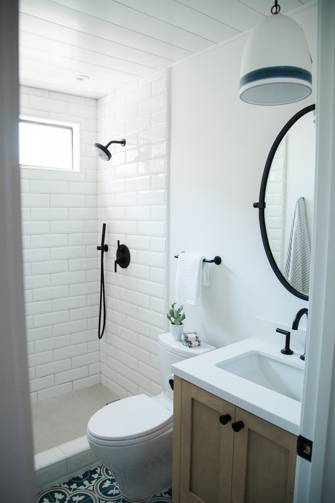 Inspiration for a small coastal 3/4 white tile and ceramic tile cement tile floor and blue floor alcove shower remodel in Orange County with shaker cabinets, light wood cabinets, a two-piece toilet, white walls, an undermount sink, quartz countertops and white countertops