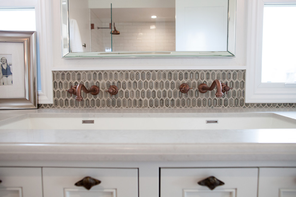 Photo of a medium sized beach style shower room bathroom in San Francisco with recessed-panel cabinets, white cabinets, an alcove shower, a two-piece toilet, beige tiles, grey tiles, multi-coloured tiles, mosaic tiles, white walls, dark hardwood flooring, a built-in sink and engineered stone worktops.