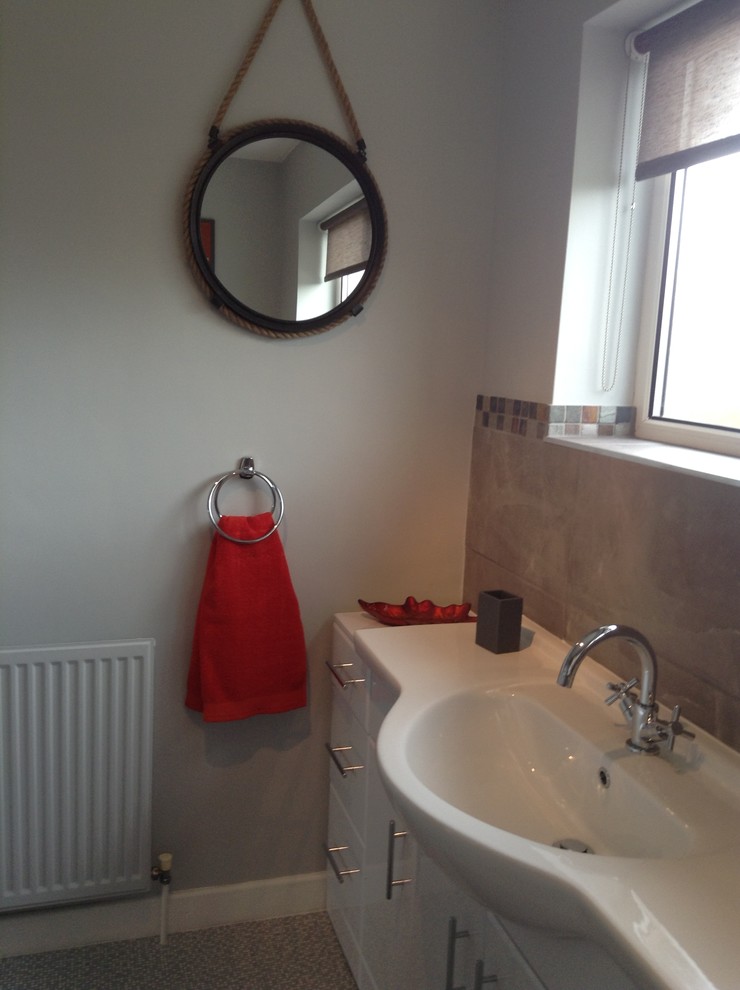 Photo of a medium sized contemporary ensuite bathroom in Cheshire with flat-panel cabinets, white cabinets, a walk-in shower, a two-piece toilet, grey tiles, mosaic tiles, grey walls, vinyl flooring, a trough sink and laminate worktops.