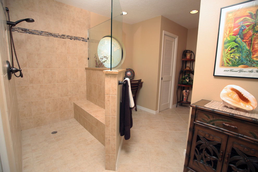 Large traditional ensuite bathroom in Tampa with a built-in shower, beige tiles, ceramic tiles, beige walls, ceramic flooring, granite worktops, raised-panel cabinets, dark wood cabinets and beige floors.