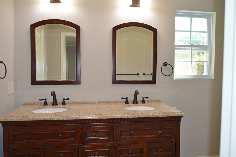 Trendy master bathroom photo in Dallas with recessed-panel cabinets, dark wood cabinets, beige walls, an undermount sink and granite countertops