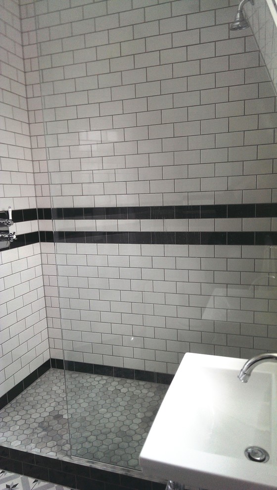 Kleines Modernes Duschbad mit Waschtischkonsole, Glasfronten, offener Dusche, Wandtoilette, weißen Fliesen, Keramikfliesen, weißer Wandfarbe, Keramikboden, buntem Boden und Schiebetür-Duschabtrennung in London