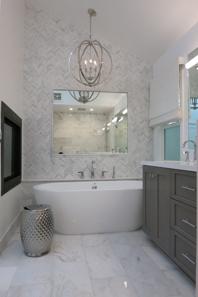 Idéer för att renovera ett mellanstort funkis vit vitt en-suite badrum, med skåp i mellenmörkt trä, ett fristående badkar, en dusch i en alkov, vit kakel, marmorkakel, vita väggar, marmorgolv, ett undermonterad handfat, bänkskiva i kvarts, vitt golv, dusch med gångjärnsdörr och skåp i shakerstil