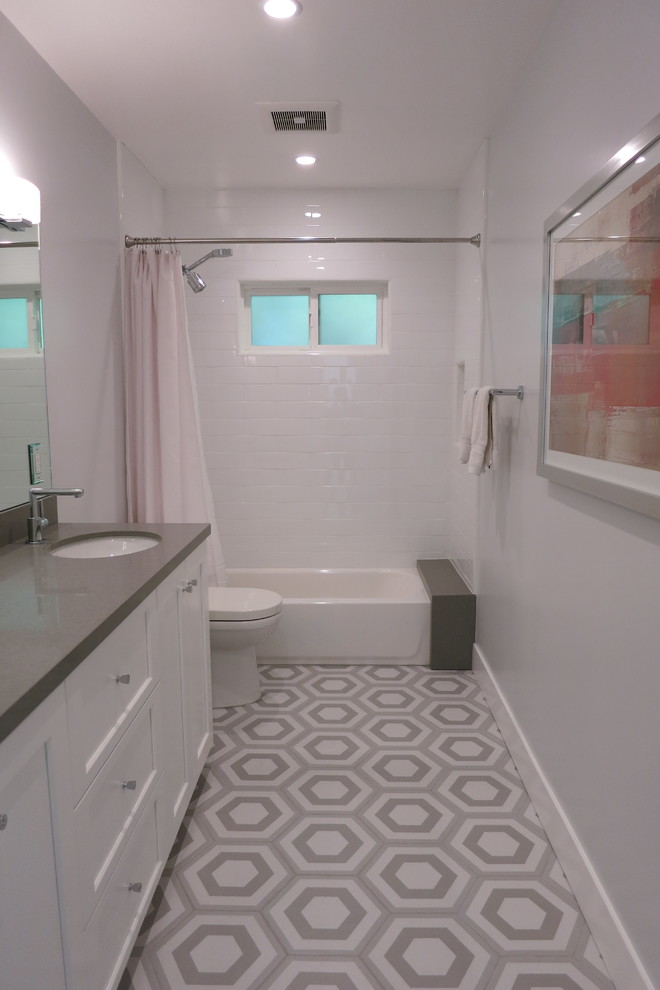 This is an example of a medium sized contemporary family bathroom in Los Angeles with shaker cabinets, white cabinets, an alcove bath, an alcove shower, white tiles, ceramic tiles, grey walls, marble flooring, a submerged sink, engineered stone worktops, multi-coloured floors, a shower curtain and grey worktops.
