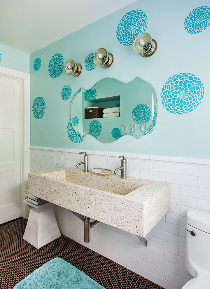 Foto på ett mellanstort funkis badrum för barn, med ett avlångt handfat, bänkskiva i betong, ett badkar i en alkov, en toalettstol med hel cisternkåpa, vit kakel, keramikplattor, blå väggar och mosaikgolv