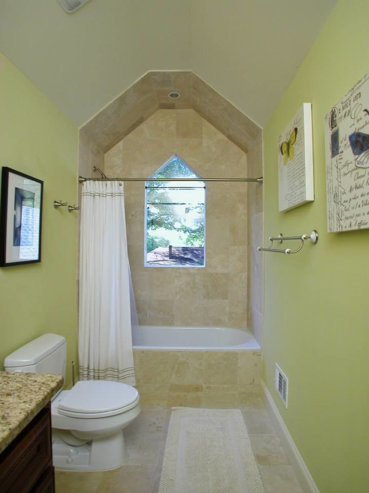 Foto de cuarto de baño tradicional de tamaño medio con lavabo bajoencimera, encimera de granito, bañera encastrada, sanitario de dos piezas, baldosas y/o azulejos beige, baldosas y/o azulejos de porcelana, paredes amarillas y suelo de travertino