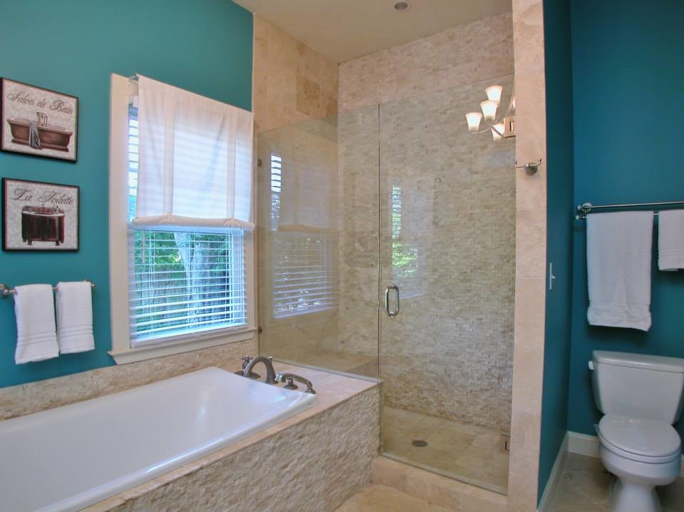 Mittelgroßes Klassisches Badezimmer En Suite mit Einbaubadewanne, offener Dusche, Wandtoilette mit Spülkasten, beigen Fliesen, Porzellanfliesen, blauer Wandfarbe und Travertin in Atlanta