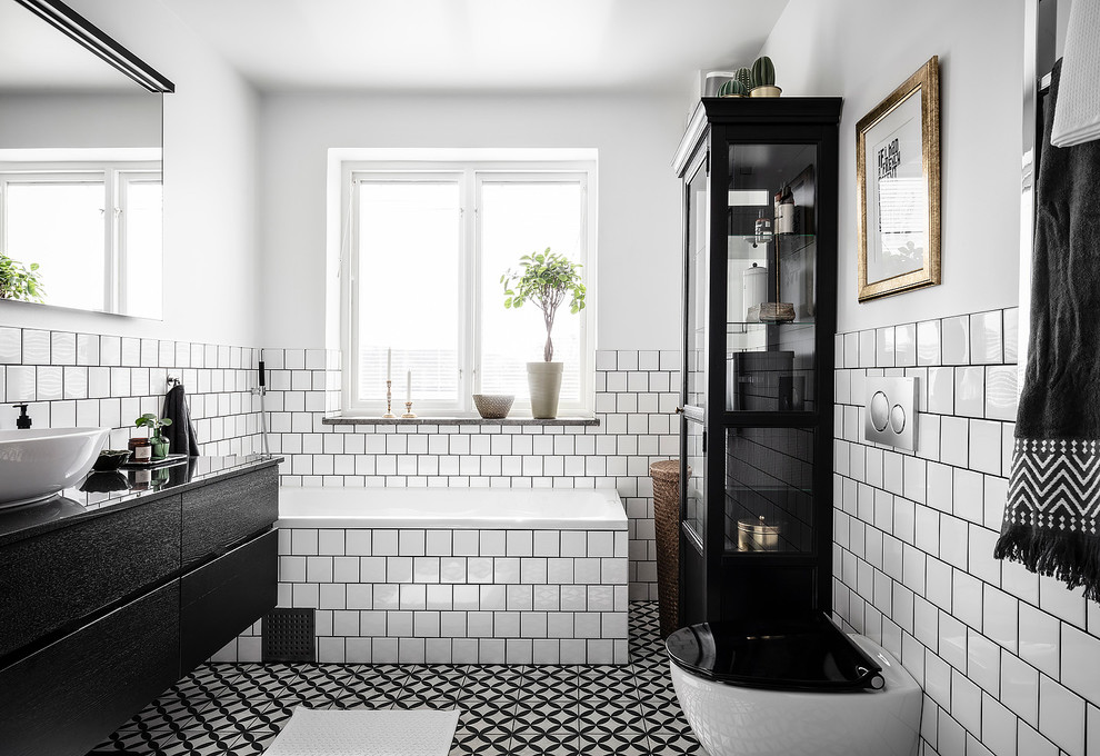 Idéer för att renovera ett stort nordiskt svart svart en-suite badrum, med möbel-liknande, skåp i mörkt trä, en öppen dusch, en vägghängd toalettstol, vit kakel, keramikplattor, vita väggar, cementgolv, granitbänkskiva, flerfärgat golv och med dusch som är öppen