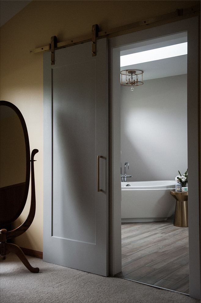 Inspiration for a medium sized classic ensuite bathroom in Chicago with shaker cabinets, grey cabinets, a freestanding bath, a walk-in shower, a two-piece toilet, grey tiles, porcelain tiles, grey walls, porcelain flooring, a submerged sink, engineered stone worktops, multi-coloured floors, a hinged door and white worktops.