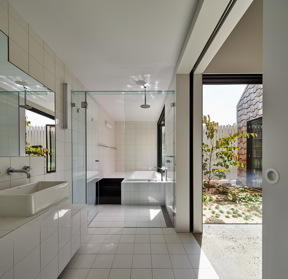 Idéer för mellanstora funkis badrum, med ett fristående handfat, ett platsbyggt badkar, en kantlös dusch, vit kakel och kaklad bänkskiva