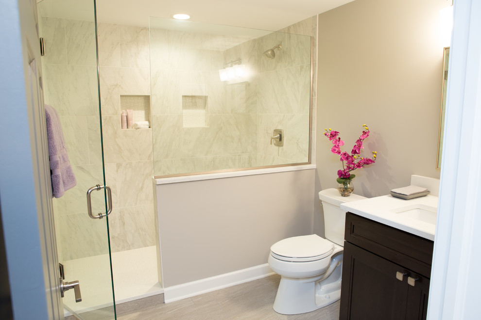 Example of a mid-sized transitional 3/4 multicolored tile and ceramic tile porcelain tile and gray floor alcove shower design in Chicago with recessed-panel cabinets, brown cabinets, a two-piece toilet, beige walls, an undermount sink, quartz countertops, a hinged shower door and white countertops