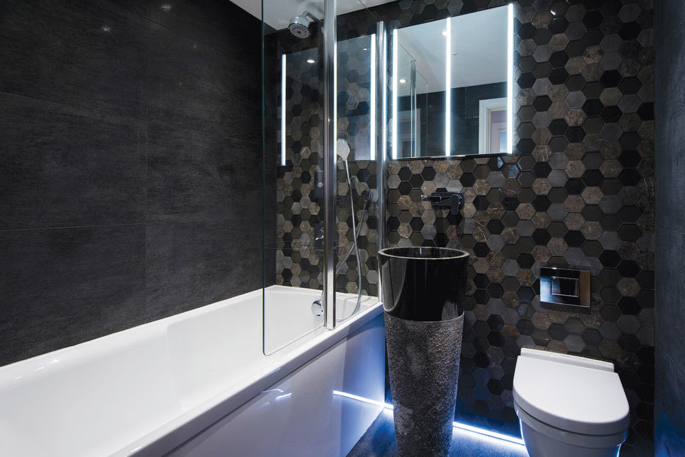 Bild på ett litet funkis badrum med dusch, med en dusch/badkar-kombination, en vägghängd toalettstol, mosaik, svarta väggar, ett piedestal handfat, svart golv, ett badkar i en alkov, svart kakel, brun kakel, grå kakel och med dusch som är öppen