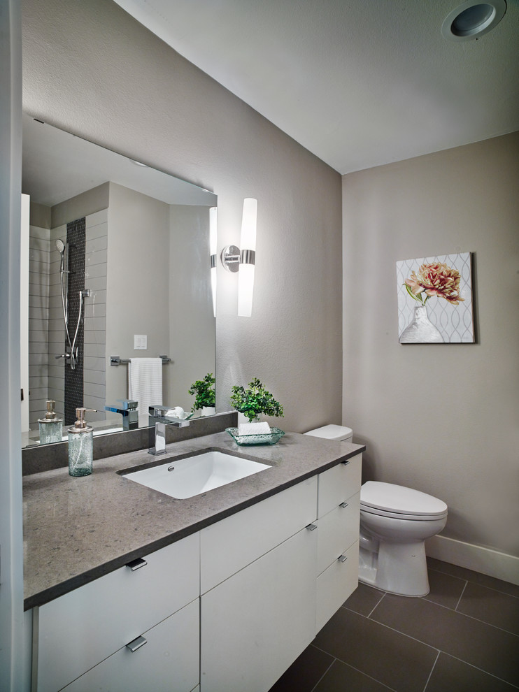 На фото: большая ванная комната в современном стиле с плоскими фасадами, белыми фасадами, открытым душем, раздельным унитазом, серой плиткой, керамогранитной плиткой, серыми стенами, полом из керамогранита, душевой кабиной, врезной раковиной и столешницей из искусственного кварца