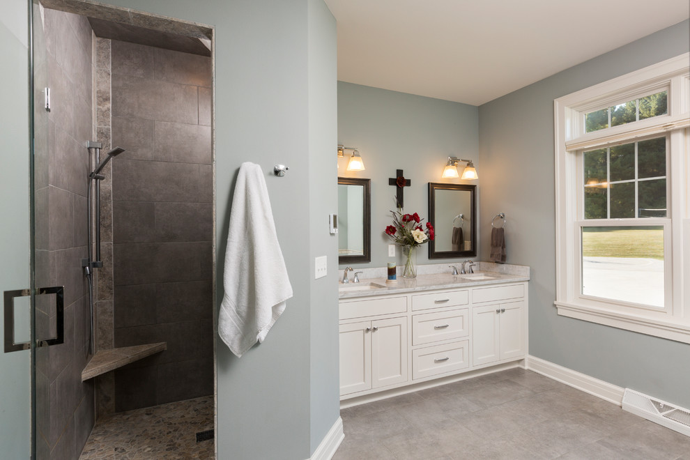 Amerikansk inredning av ett stort vit vitt en-suite badrum, med släta luckor, vita skåp, ett platsbyggt badkar, en dusch i en alkov, grå kakel, keramikplattor, blå väggar, klinkergolv i keramik, ett undermonterad handfat, marmorbänkskiva, grått golv och dusch med gångjärnsdörr