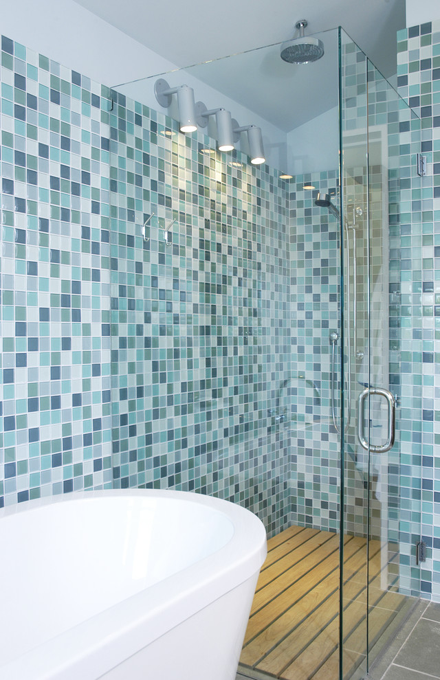 На фото: большая главная ванная комната в стиле кантри с отдельно стоящей ванной, открытым душем, унитазом-моноблоком, синей плиткой, плиткой из листового стекла и синими стенами с