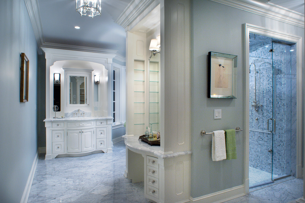 Klassisk inredning av ett stort en-suite badrum, med luckor med infälld panel, vita skåp, ett fristående badkar, en dusch i en alkov, blå kakel, mosaik, blå väggar, marmorgolv, ett undermonterad handfat och marmorbänkskiva