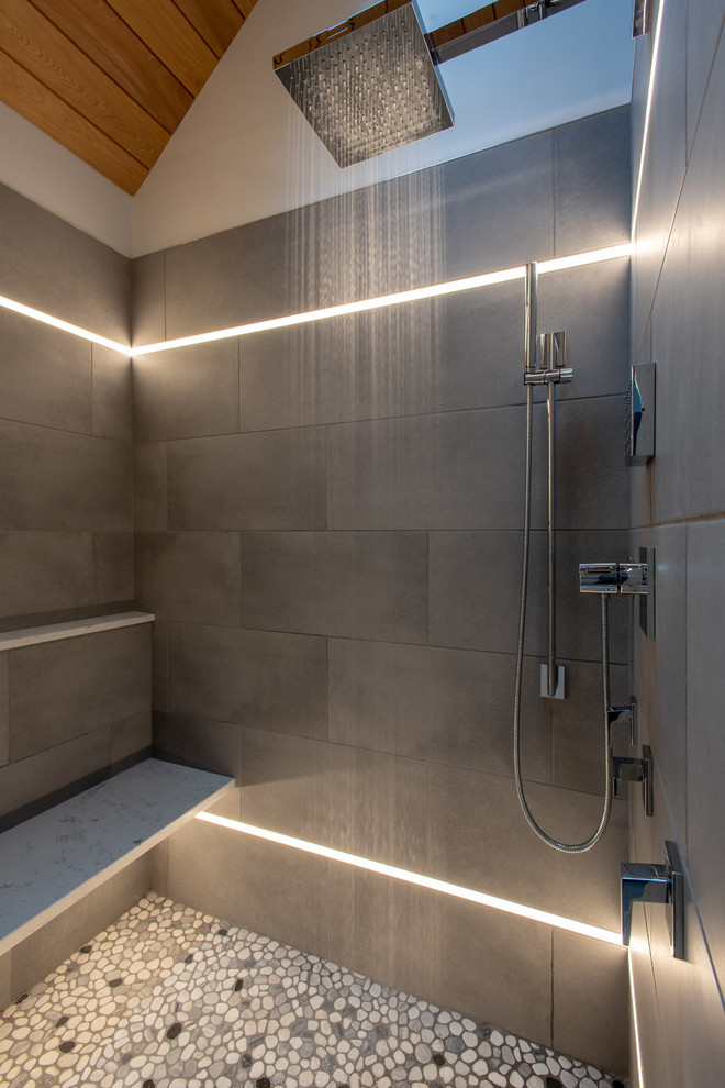 Cette photo montre une salle de bain principale tendance avec un carrelage gris, des carreaux de porcelaine et une cabine de douche à porte battante.