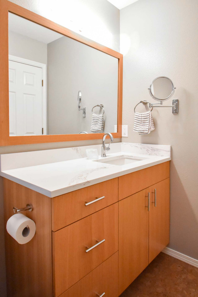 Пример оригинального дизайна: маленькая ванная комната в стиле модернизм с плоскими фасадами, светлыми деревянными фасадами, душем над ванной, раздельным унитазом, белой плиткой, плиткой кабанчик, бежевыми стенами, пробковым полом, душевой кабиной, врезной раковиной, столешницей из искусственного кварца, красным полом, шторкой для ванной, белой столешницей, нишей, тумбой под одну раковину и встроенной тумбой для на участке и в саду