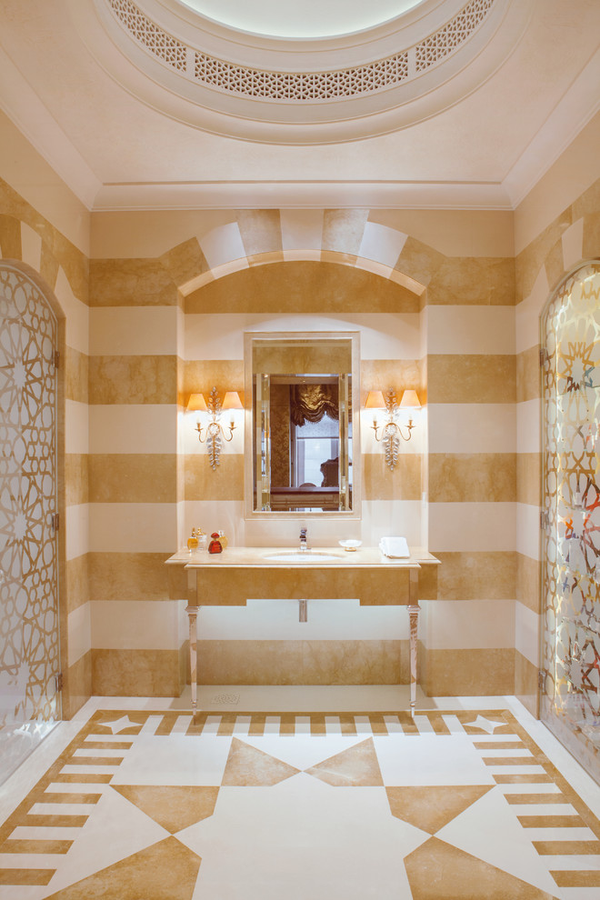 Immagine di una stanza da bagno mediterranea con lavabo sottopiano, piastrelle beige e pareti multicolore