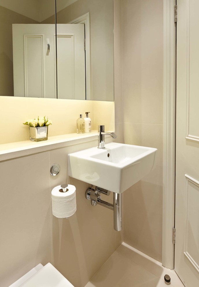 Design ideas for a medium sized classic ensuite bathroom in London with a wall-mounted sink, flat-panel cabinets, limestone worktops, an alcove shower, a one-piece toilet, beige tiles, porcelain tiles, white walls and porcelain flooring.
