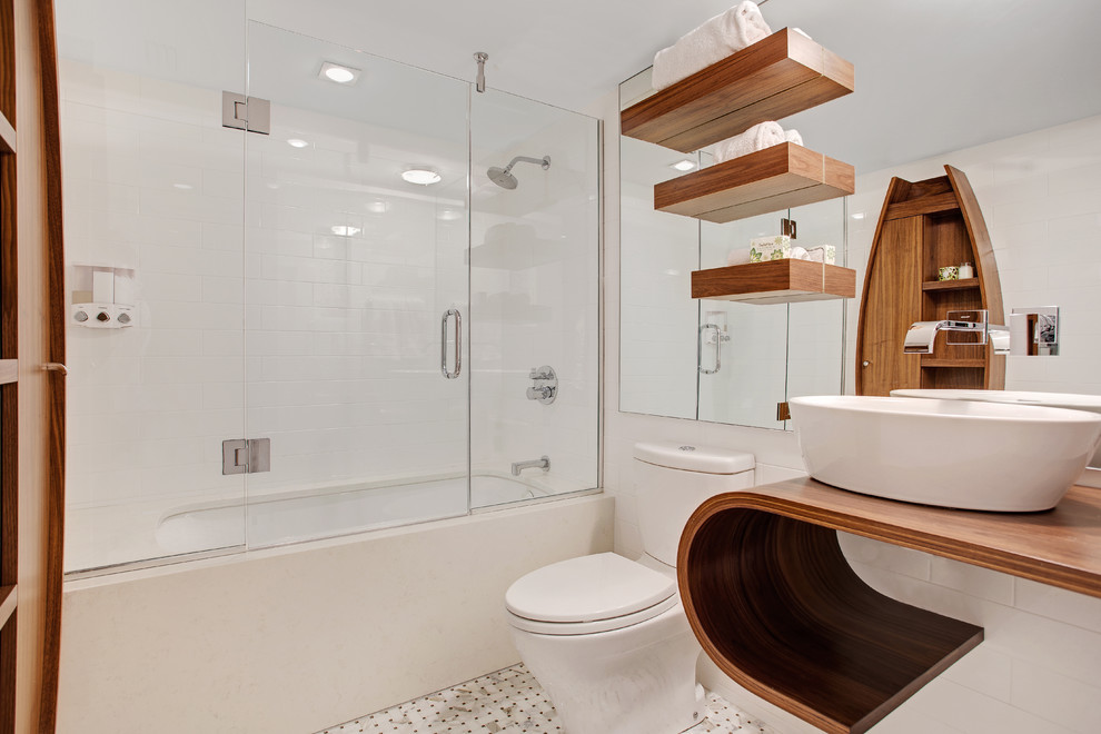Idéer för ett modernt badrum, med ett fristående handfat, träbänkskiva, ett undermonterat badkar, en dusch/badkar-kombination, en toalettstol med separat cisternkåpa, vit kakel och mosaikgolv