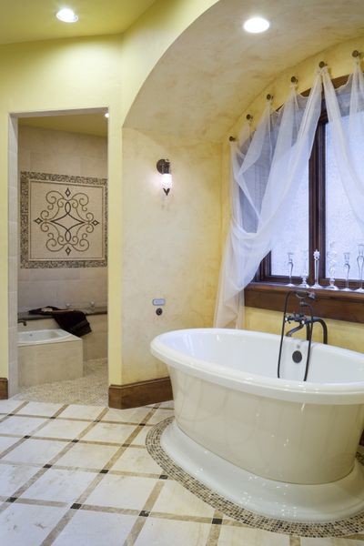 Réalisation d'une salle de bain principale tradition de taille moyenne avec une baignoire indépendante, une douche d'angle, un mur jaune, un sol en marbre, un sol blanc et aucune cabine.