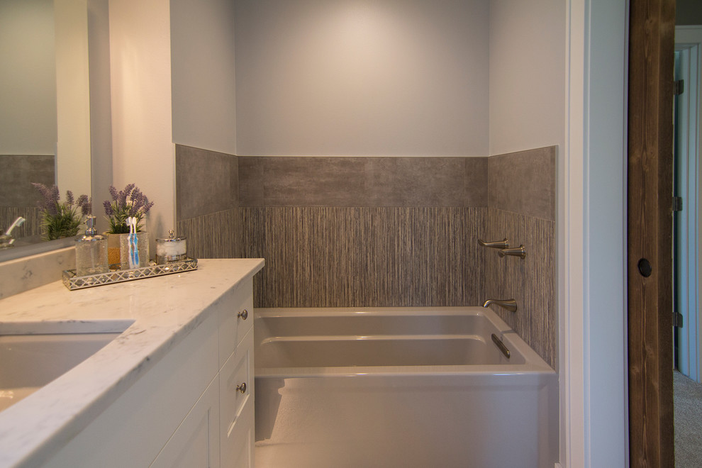 Inspiration for a mid-sized contemporary master gray tile and porcelain tile vinyl floor bathroom remodel in Milwaukee with shaker cabinets, white cabinets, a two-piece toilet, gray walls, an undermount sink and granite countertops