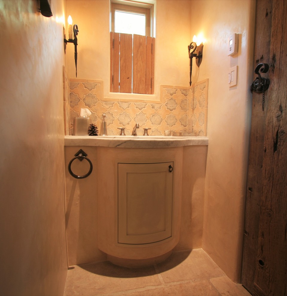 デンバーにある小さなトラディショナルスタイルのおしゃれな浴室 (ベージュのキャビネット、ベージュのタイル、ベージュの壁、一体型シンク、大理石の洗面台、レイズドパネル扉のキャビネット、スレートの床) の写真