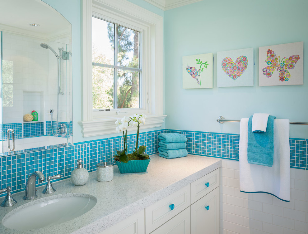 Esempio di una stanza da bagno per bambini tradizionale con lavabo sottopiano, ante a filo, top in vetro riciclato, piastrelle blu, piastrelle in ceramica, pareti blu e pavimento in gres porcellanato