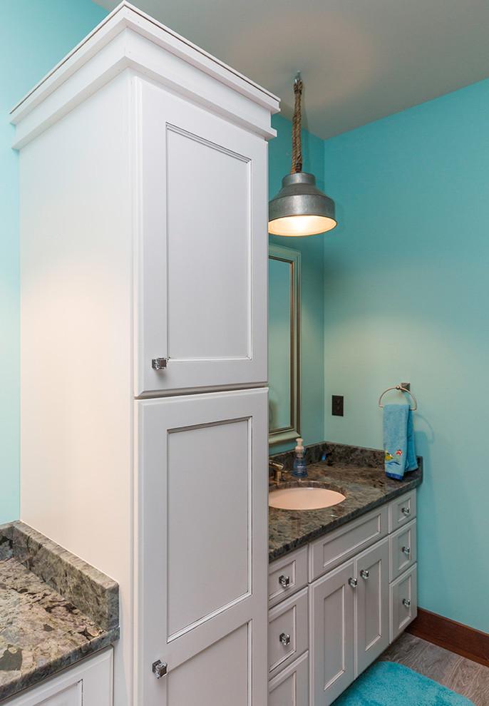 Ejemplo de cuarto de baño tradicional con puertas de armario blancas y paredes azules