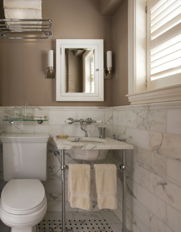 На фото: ванная комната в классическом стиле с консольной раковиной и мраморной плиткой с