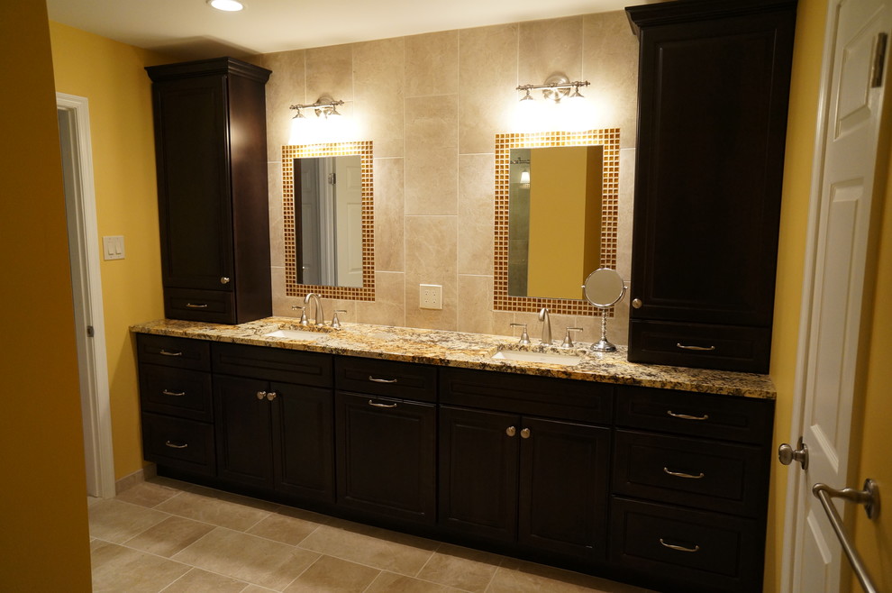 Photo of a large classic ensuite bathroom in Philadelphia with a submerged sink, raised-panel cabinets, medium wood cabinets, granite worktops, an alcove shower, a two-piece toilet, beige tiles, porcelain tiles, beige walls and porcelain flooring.