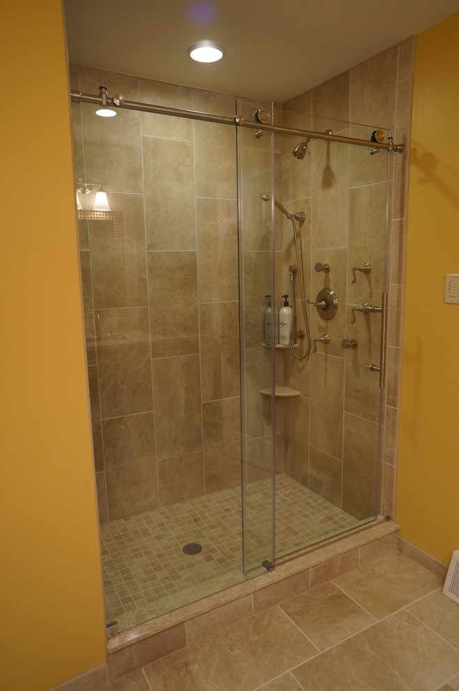 Alcove shower - large traditional master beige tile and porcelain tile porcelain tile alcove shower idea in Philadelphia with an undermount sink, raised-panel cabinets, medium tone wood cabinets, granite countertops, a two-piece toilet and beige walls