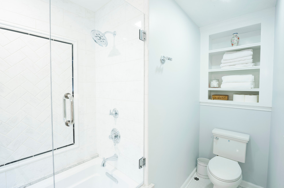 Design ideas for a medium sized traditional ensuite bathroom in Indianapolis with a submerged sink, raised-panel cabinets, black cabinets, engineered stone worktops, a built-in bath, a shower/bath combination, a two-piece toilet, white tiles, ceramic tiles, blue walls and ceramic flooring.