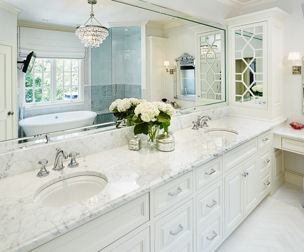 Corner shower - large traditional master white tile and stone slab marble floor corner shower idea in Dallas with a drop-in sink, recessed-panel cabinets, white cabinets, marble countertops and white walls