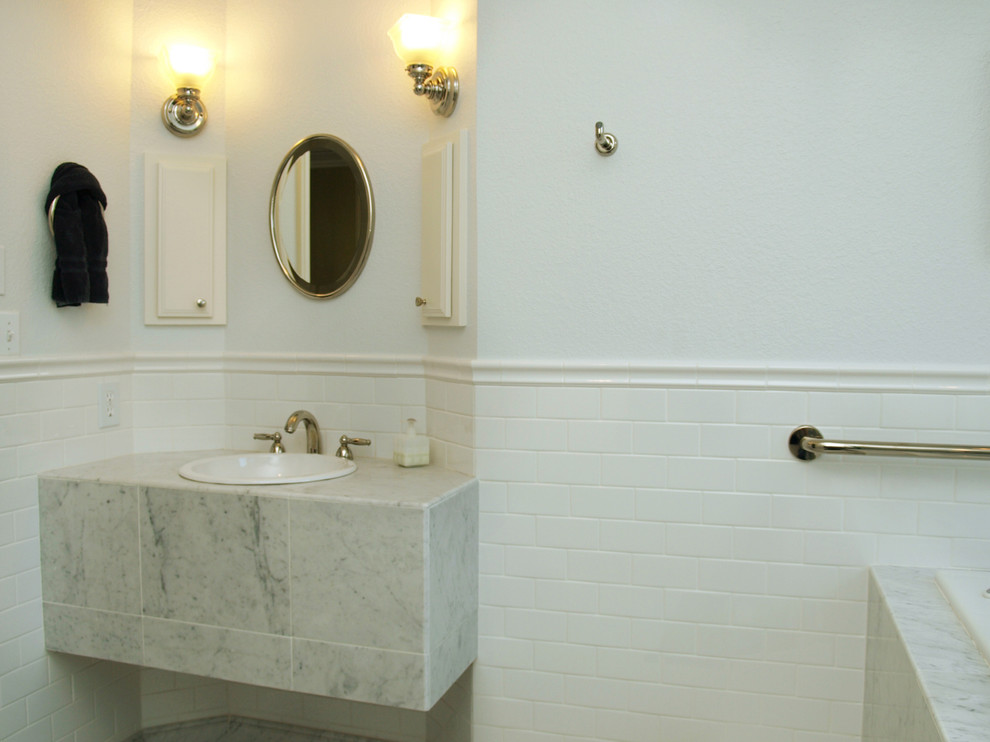 Esempio di una stanza da bagno padronale classica di medie dimensioni con pareti bianche, pavimento in marmo, lavabo da incasso, top in marmo, ante con bugna sagomata, ante bianche, vasca giapponese, doccia ad angolo, piastrelle grigie e piastrelle di marmo