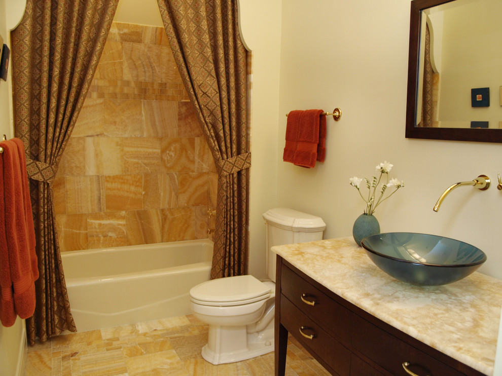 Exempel på ett mellanstort klassiskt badrum, med släta luckor, skåp i mörkt trä, ett badkar i en alkov, en dusch/badkar-kombination, en toalettstol med separat cisternkåpa, ett fristående handfat, bänkskiva i onyx, flerfärgad kakel, marmorkakel, gula väggar och marmorgolv