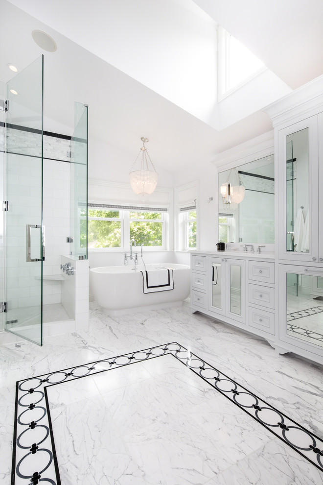Klassisches Badezimmer mit Kassettenfronten, weißen Schränken, freistehender Badewanne, Eckdusche, weißer Wandfarbe und Falttür-Duschabtrennung in Los Angeles
