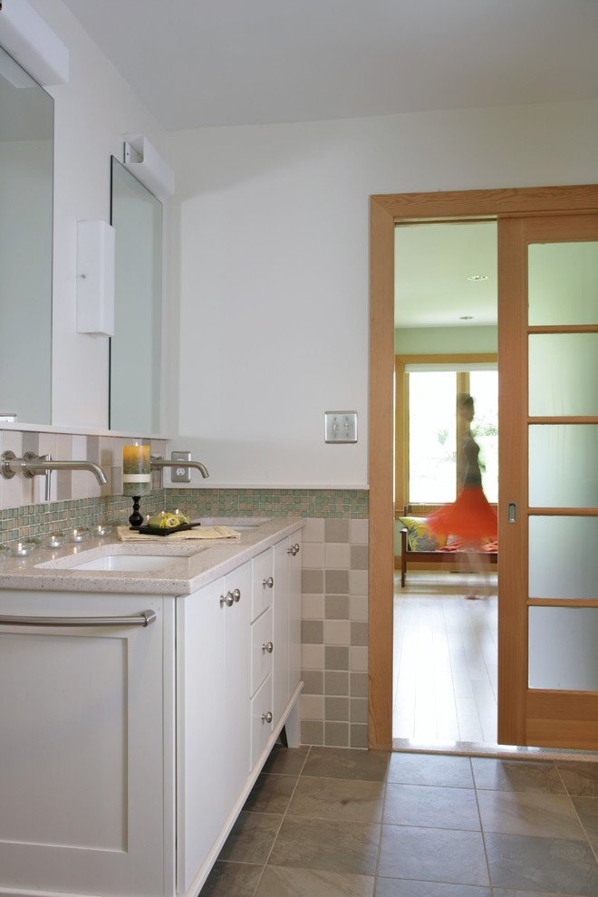 Modelo de cuarto de baño con puerta corredera clásico con baldosas y/o azulejos de piedra y lavabo bajoencimera